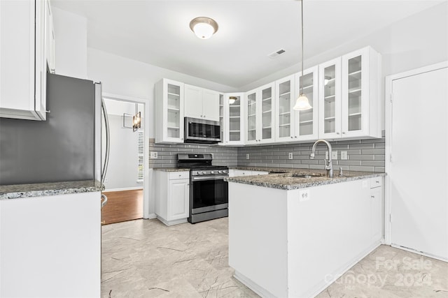 kitchen with white cabinets, sink, decorative backsplash, light stone countertops, and stainless steel appliances