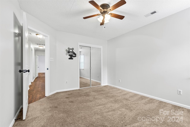 unfurnished bedroom with ceiling fan, a closet, carpet, and a textured ceiling