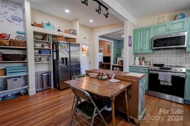 kitchen with tasteful backsplash, stainless steel appliances, dark hardwood / wood-style floors, and green cabinetry