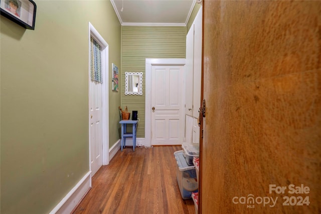 hallway featuring ornamental molding and hardwood / wood-style flooring