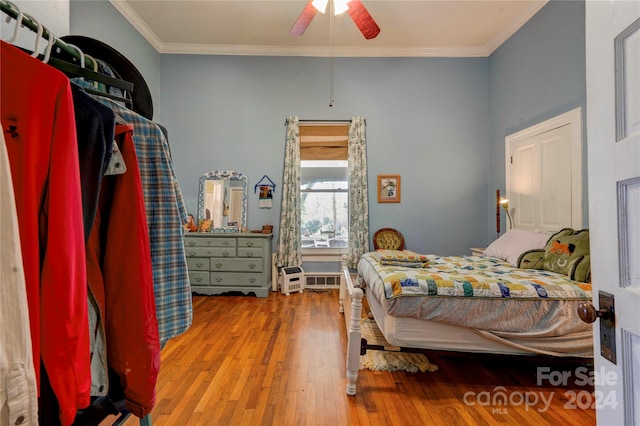 bedroom with ceiling fan, crown molding, and light wood-type flooring