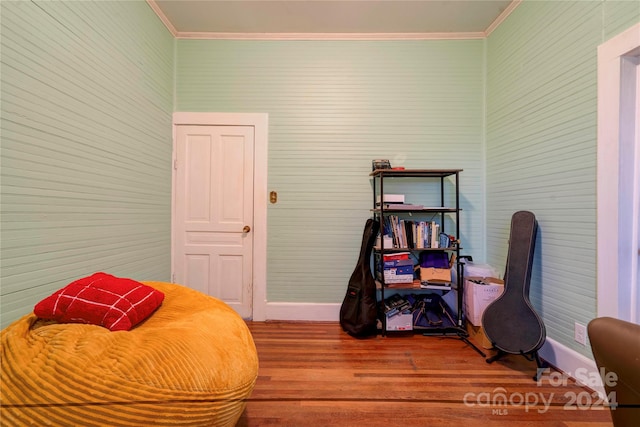 living area featuring crown molding and hardwood / wood-style floors