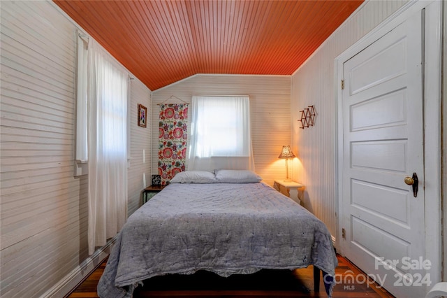 bedroom with hardwood / wood-style floors, wooden walls, wooden ceiling, and lofted ceiling