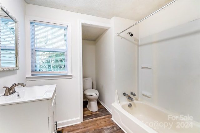 full bathroom featuring hardwood / wood-style floors, vanity, toilet, and shower / tub combination