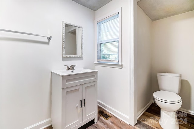 bathroom with vanity, hardwood / wood-style flooring, and toilet