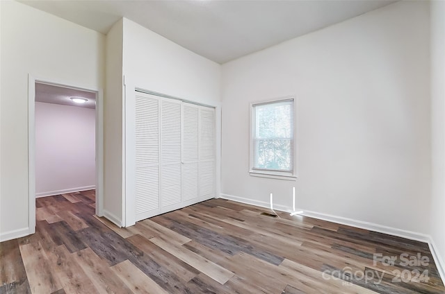 unfurnished bedroom with a closet and wood-type flooring