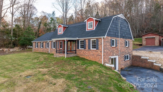 view of front of house featuring an outbuilding, a front yard, and a garage