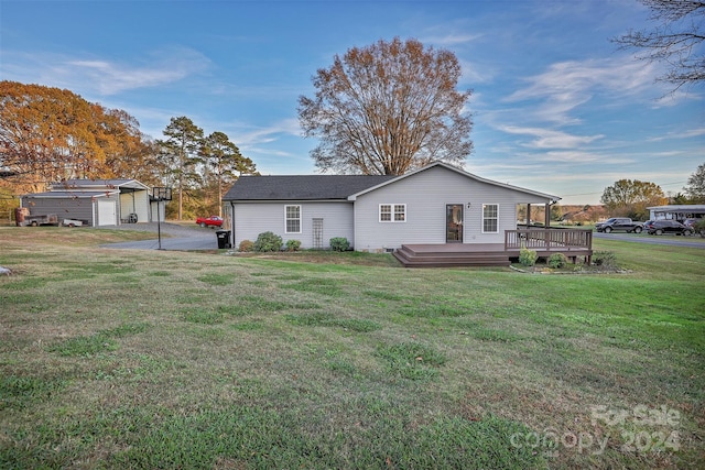 back of house featuring a lawn and a wooden deck