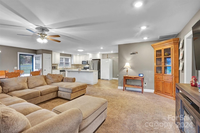 carpeted living room featuring ceiling fan