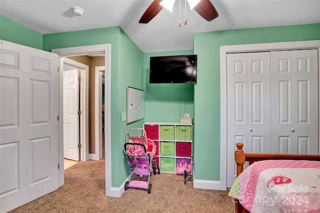 bedroom with ceiling fan, light carpet, and a closet