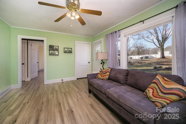 living room with ornamental molding, ceiling fan, and light hardwood / wood-style flooring