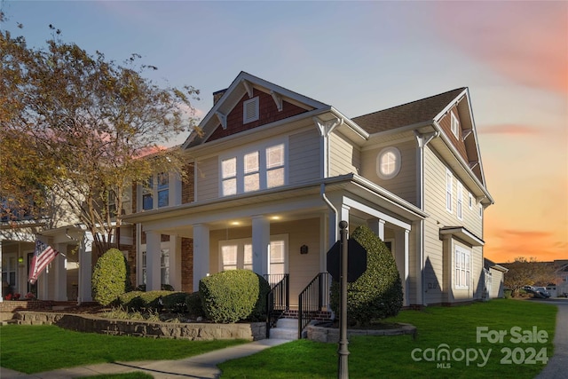 view of front of home featuring a lawn and covered porch