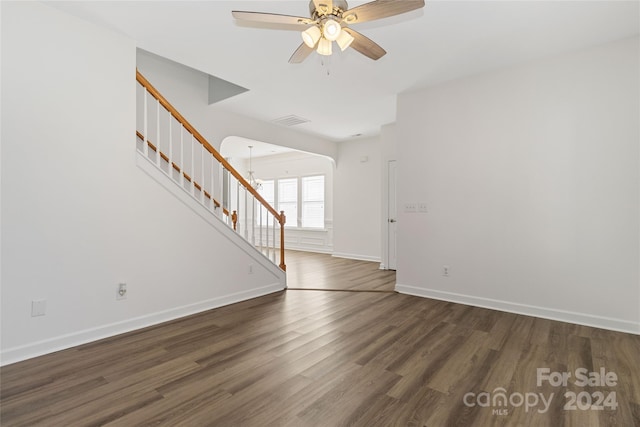 interior space featuring ceiling fan with notable chandelier and dark hardwood / wood-style flooring