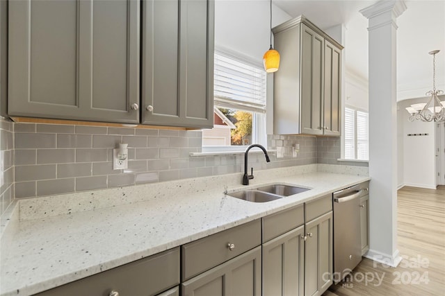 kitchen with light hardwood / wood-style floors, stainless steel dishwasher, hanging light fixtures, and sink