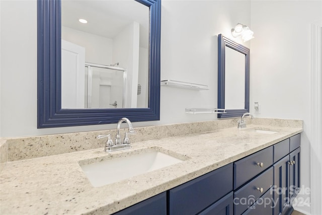 bathroom with a shower with door and vanity