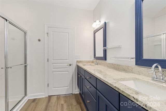 bathroom with vanity, wood-type flooring, and a shower with door