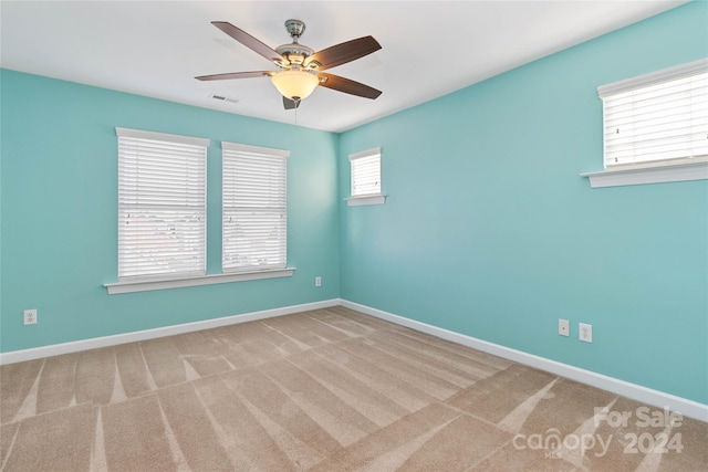 spare room featuring ceiling fan and light colored carpet