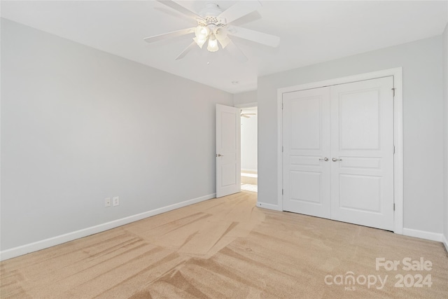 unfurnished bedroom with ceiling fan, a closet, and light colored carpet