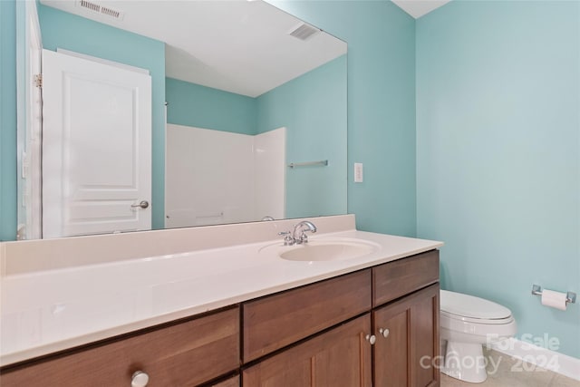 bathroom featuring vanity, toilet, and walk in shower