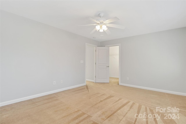 spare room with ceiling fan and light colored carpet