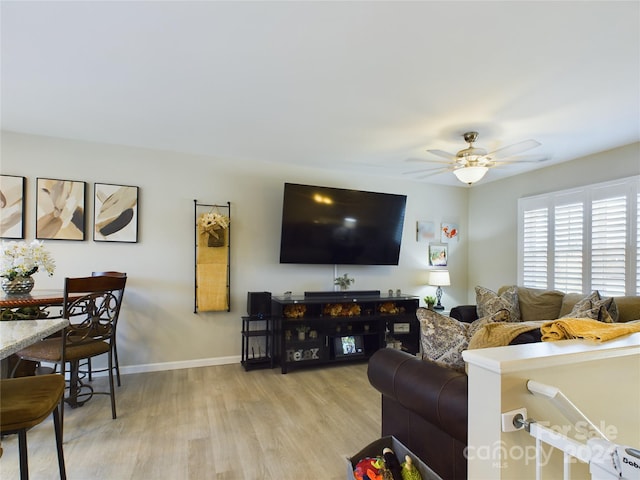 living room featuring light wood-type flooring and ceiling fan