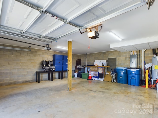 garage featuring electric panel, water heater, and a garage door opener