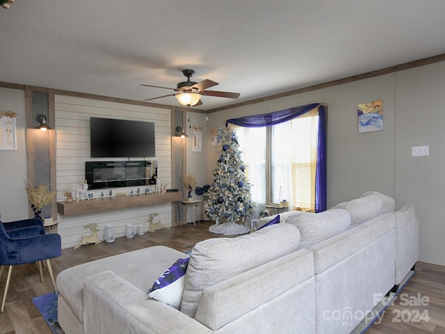 living room with dark hardwood / wood-style floors, ceiling fan, and crown molding