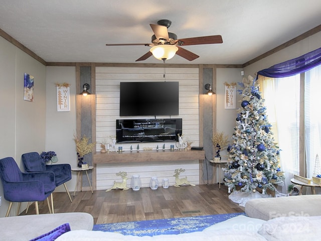 living room with ceiling fan, a healthy amount of sunlight, wood-type flooring, and crown molding