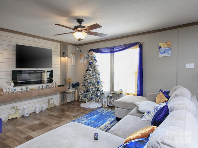 living room with hardwood / wood-style flooring, ceiling fan, and crown molding