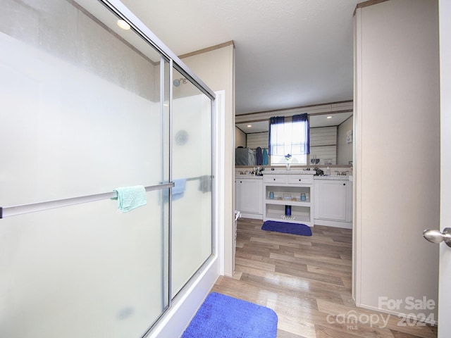 bathroom featuring wood-type flooring, vanity, and walk in shower