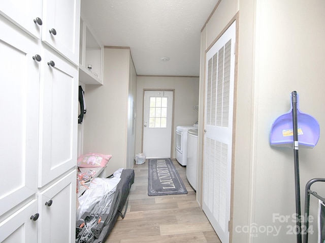 laundry room with cabinets, separate washer and dryer, and light hardwood / wood-style flooring