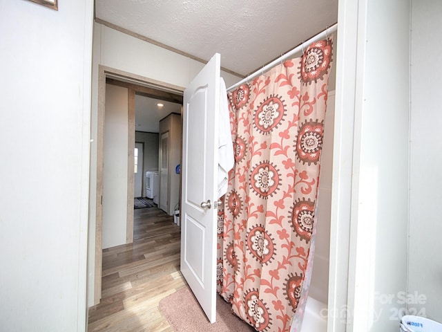 bathroom featuring wood-type flooring and a textured ceiling