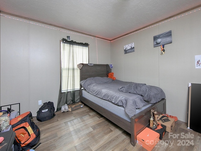 bedroom featuring light wood-type flooring and a textured ceiling