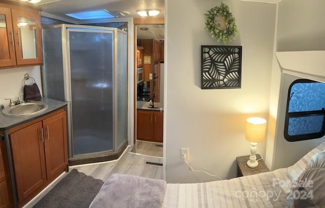 bathroom featuring wood-type flooring, vanity, and an enclosed shower