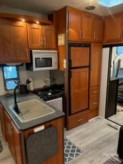 kitchen with sink and light hardwood / wood-style flooring