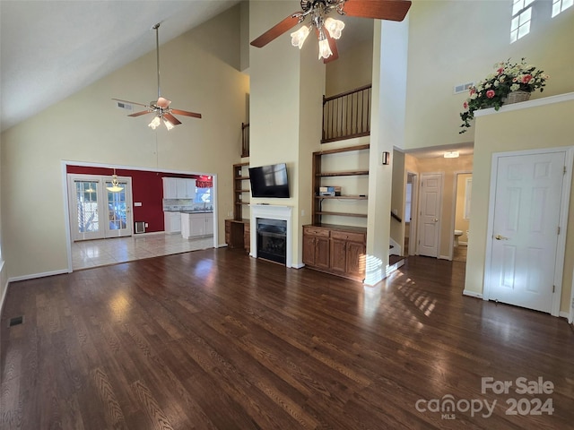 unfurnished living room featuring ceiling fan, french doors, high vaulted ceiling, and hardwood / wood-style flooring