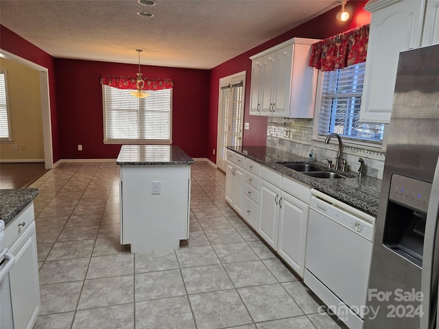 kitchen featuring white cabinets, white dishwasher, a kitchen island, and plenty of natural light