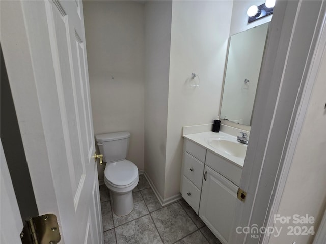 bathroom with tile patterned flooring, vanity, and toilet