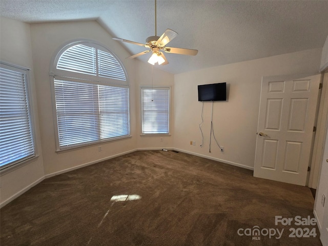 carpeted spare room with ceiling fan, a textured ceiling, and vaulted ceiling