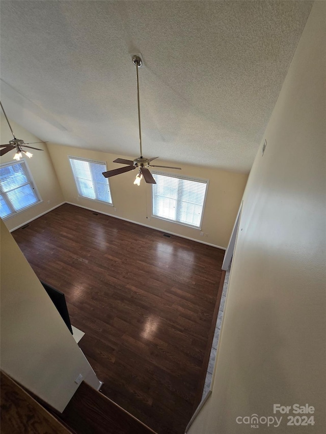 unfurnished living room with dark hardwood / wood-style floors, a healthy amount of sunlight, and vaulted ceiling