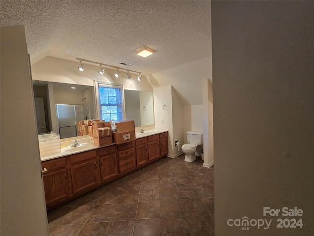 bathroom featuring a textured ceiling, an enclosed shower, vaulted ceiling, and toilet