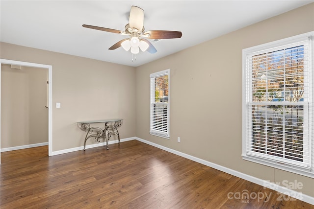 unfurnished room with ceiling fan and dark hardwood / wood-style flooring