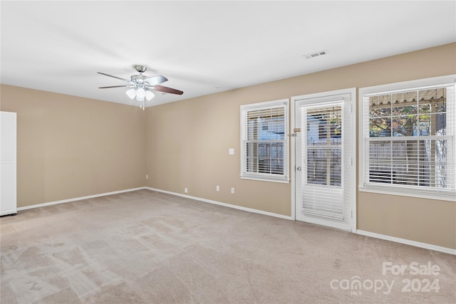 empty room featuring ceiling fan and light colored carpet