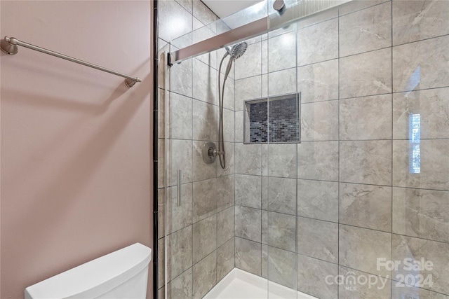 bathroom featuring toilet and an enclosed shower