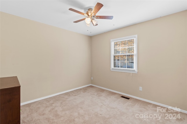 spare room with light colored carpet and ceiling fan