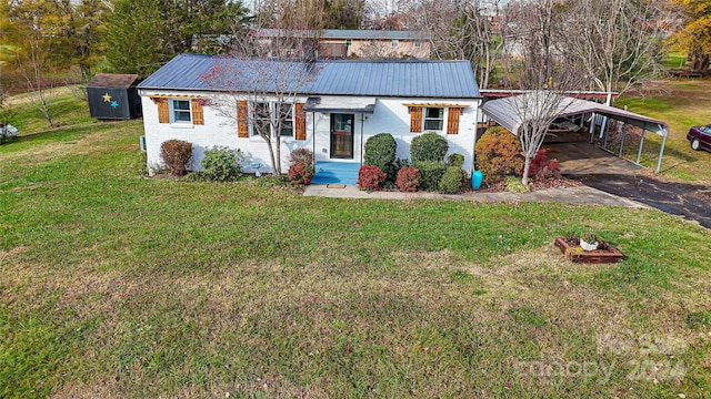 view of front of property featuring a front lawn, a storage unit, and a carport