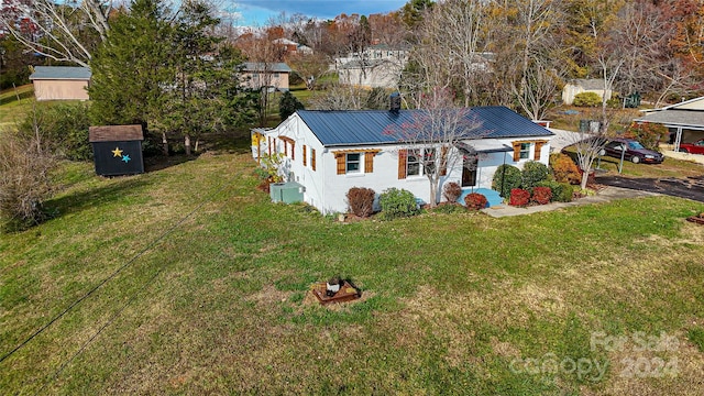 view of front of property featuring a shed and a front lawn