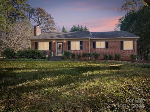 ranch-style home featuring a yard