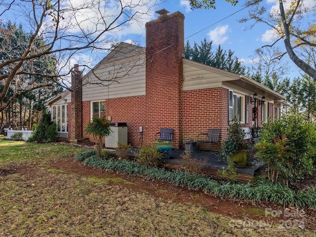 view of side of home with central AC unit