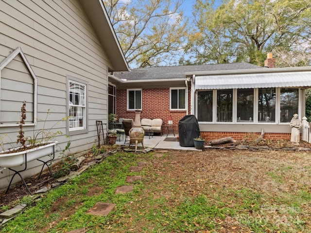 rear view of property with a sunroom and a patio area